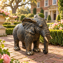 Load image into Gallery viewer, Classic aged gold polyresin elephant with lowered trunk in a luxurious garden