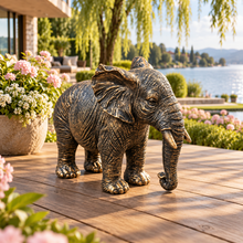 Load image into Gallery viewer, Classic aged gold polyresin elephant with lowered trunk in a luxurious garden