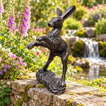 Indlæs billede til gallerivisning Bronze boxing hare garden ornament in a cottage garden with colourful flowers and waterfall