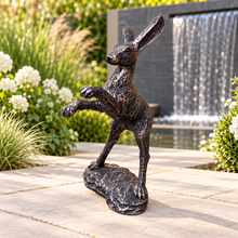 Indlæs billede til gallerivisning Bronze boxing hare garden ornament in a modern garden with white flowers and waterfall