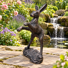 Indlæs billede til gallerivisning Bronze boxing hare garden ornament in a traditional garden with roses and waterfall
