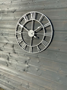 Silver framed Skeleton clock with silver numerals and silver hands