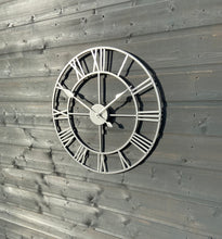 Laden Sie das Bild in den Galerie-Viewer, Silver framed Skeleton clock with silver numerals and silver hands
