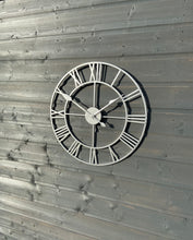Laden Sie das Bild in den Galerie-Viewer, Silver framed Skeleton clock with silver numerals and silver hands
